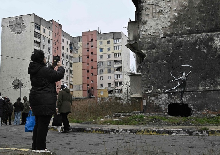 バンクシーの作品を写真に収める地元住民＝２０２２年１１月１２日、イルピン/Genya Savilov/AFP/Getty Images